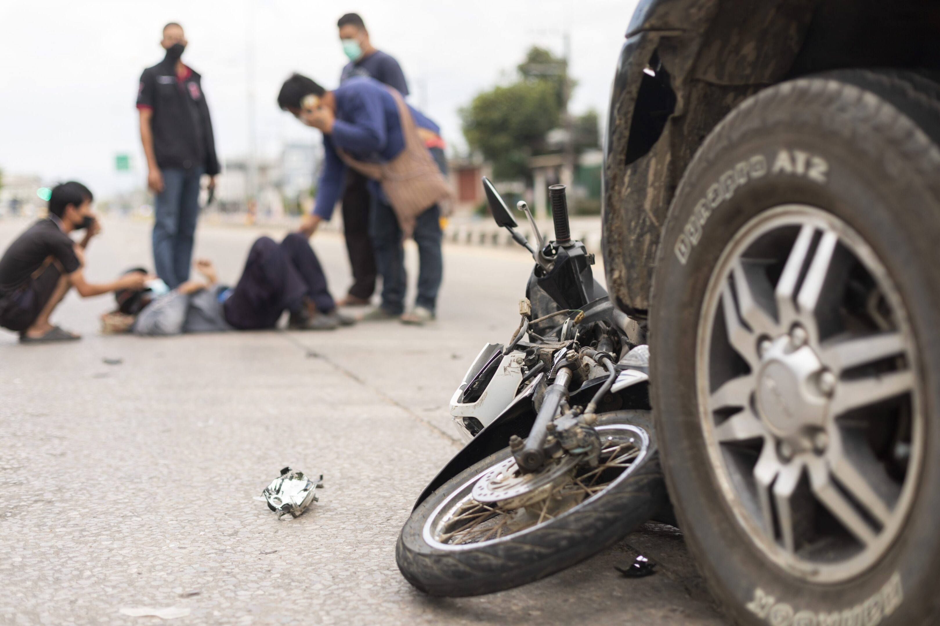 Mae Sot, Tak, Thailand - March 23, 2022 : The condition of the motorcycle was hit by a car and there was serious injure man lying on the road at Mae Sot, Tak, Thailand.