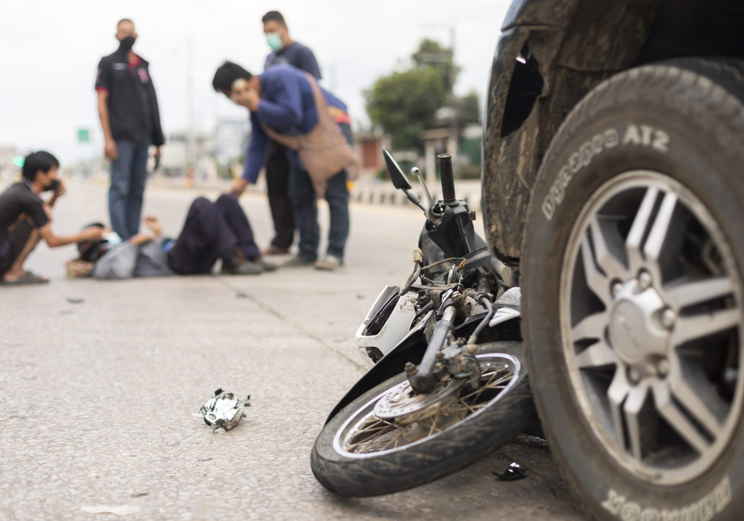 Mae Sot, Tak, Thailand - March 23, 2022 : The condition of the motorcycle was hit by a car and there was serious injure man lying on the road at Mae Sot, Tak, Thailand.